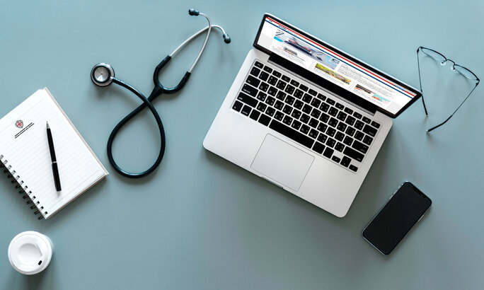 Farmacista che aiuta un cliente a prenotare una visita al computer